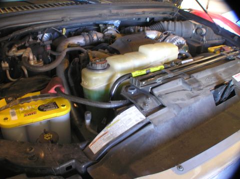 2000 Ford Excursion - Engine bay details with a prominent yellow Optima battery and coolant reservoir visible.