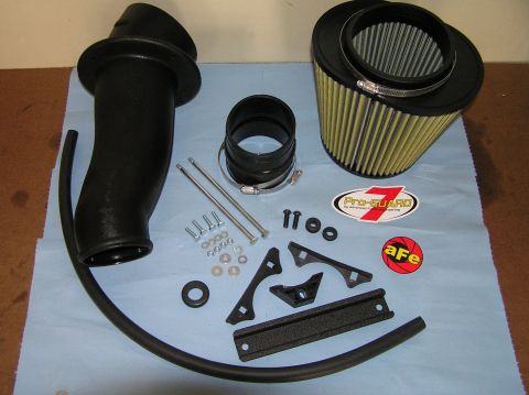 2000 Ford Excursion - AFE intake system parts laid out on a blue cloth, including an air filter and intake tube.