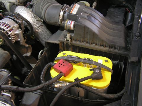 2000 Ford Excursion - Engine bay view showing a yellow Optima battery and part of the air intake system.