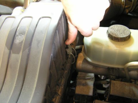 2000 Ford Excursion - Close-up view of engine components, including the air filter housing and brake fluid reservoir.