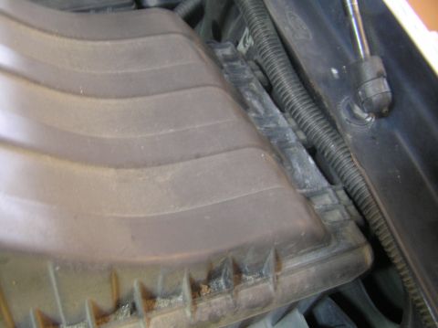 2000 Ford Excursion - Close-up view of the engine bay air intake housing, showing its ribbed cover and associated wiring.