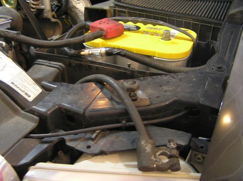 2000 Ford Excursion - Close-up of a car battery and associated engine bay components, including wiring and a Motorcraft label.