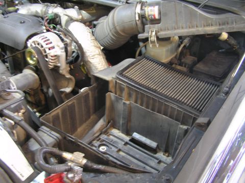 2000 Ford Excursion - The air filter housing is removed from the engine bay, revealing the intake system and other engine parts.