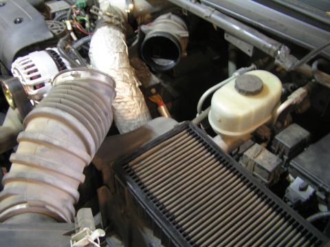 2000 Ford Excursion - Close-up of an engine bay with air intake components and brake fluid reservoir visible.