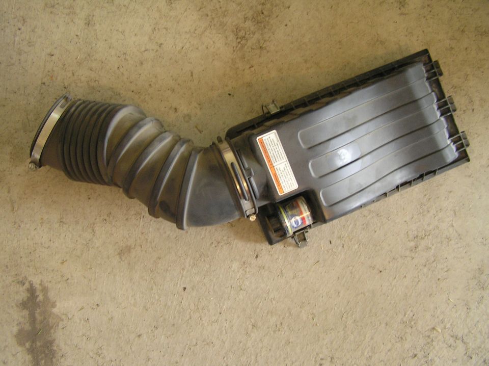 Black air intake duct and air filter housing box on concrete floor