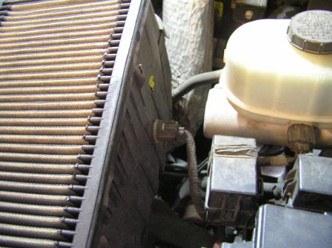 2000 Ford Excursion - Close-up view of an engine compartment showing an air filter, fluid reservoir, and electrical components.