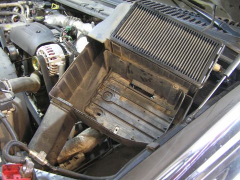 2000 Ford Excursion - The engine bay of a vehicle with the air filter housing removed, revealing the intake system and engine components.