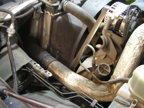 2000 Ford Excursion - Close-up view of an engine bay, focusing on the radiator and alternator components.