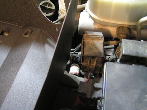 2000 Ford Excursion - Close-up view of various engine compartment components, including a fuse box and fluid reservoir.