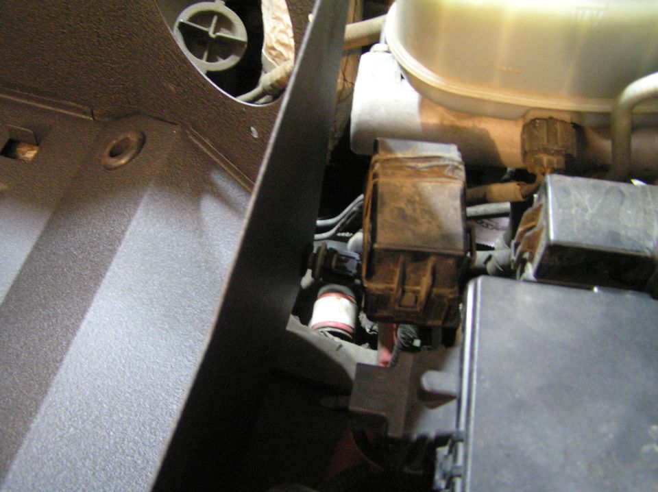 Engine bay connectors and wiring beside a fluid reservoir