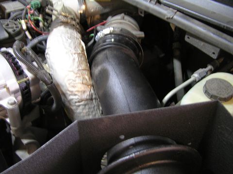 2000 Ford Excursion - Close-up view of an engine bay, focusing on the intake tube and alternator.