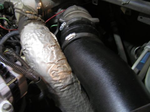 2000 Ford Excursion - Close-up of an engine intake tube and a heat shield.