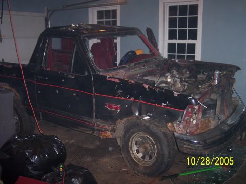 1994 Ford Bronco - This heavily damaged black Ford Bronco shows significant front-end destruction and a red interior.