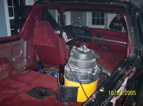 1994 Ford Bronco - Interior view of a 1994 Ford Bronco during a teardown process, with a shop vac present.