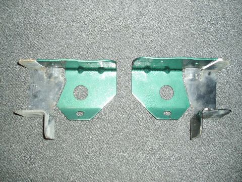 1995 Ford Taurus - Two green metal brackets, likely for automotive use, are shown against a grey carpeted background.