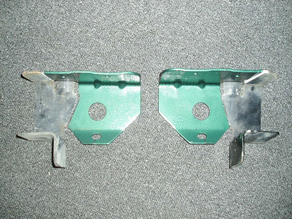 Pair of green metal brackets with circular cutouts
