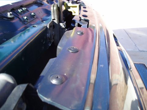 1995 Ford Taurus - Detail view of a car's hood latch mechanism, showing screws and springs.