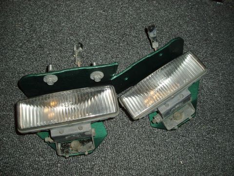 1995 Ford Taurus - Two headlight assemblies are shown mounted on green brackets against a gray carpeted background.