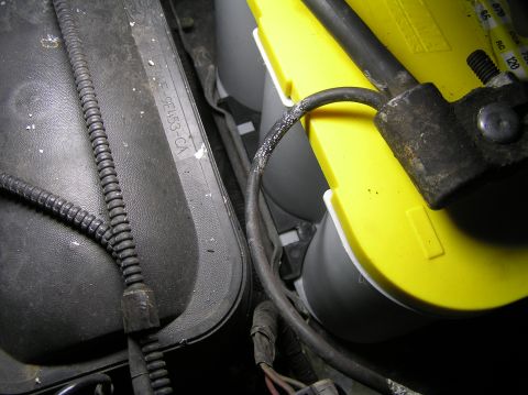 2000 Ford Excursion - Engine bay components including a yellow Optima battery and a black cover with visible part number.