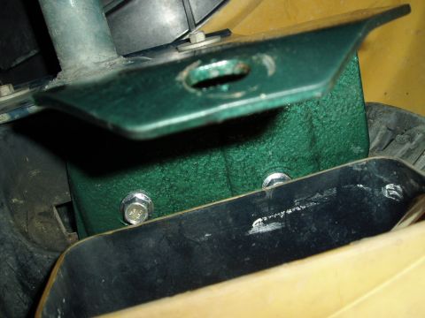 1995 Ford Taurus - Close-up view of a green metal bracket and its mounting hardware.