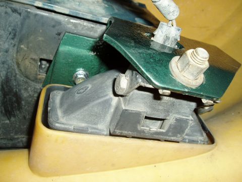 1995 Ford Taurus - Close-up of a green metal bracket attached to a car's header panel component.