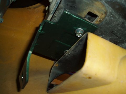1995 Ford Taurus - Close-up of a green metal bracket attached to a vehicle's header panel, with yellow plastic trim visible.