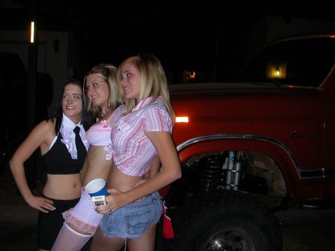 1984 Ford Bronco - A group of friends pose for a photo next to a modified SUV at an outdoor gathering.