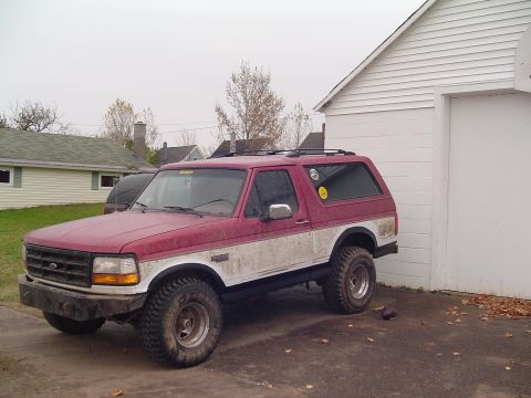 1994 Ford Bronco - This 1994 Ford Bronco features a two-tone red and white paint scheme and off-road tires.