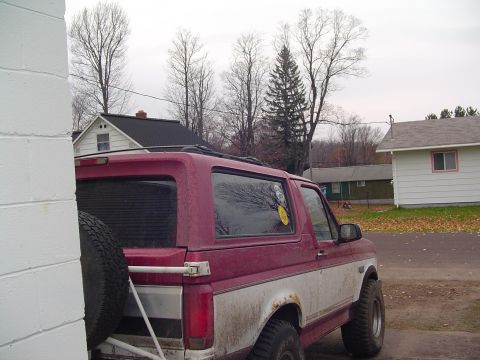1994 Ford Bronco - This Ford Bronco is parked outside a residential building on an overcast day.