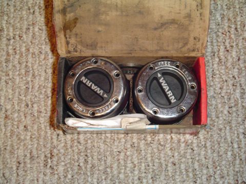 1994 Ford Bronco - Two Warn locking hubs are displayed in their original packaging, ready for installation.