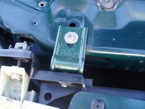 1995 Ford Taurus - A green metal bracket is attached to the vehicle's inner structure near the front.