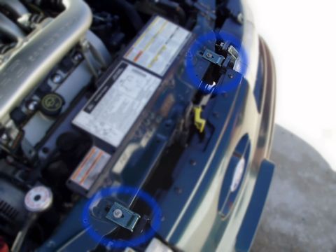 1995 Ford Taurus - Close-up of engine bay components, focusing on hood latch mechanisms.