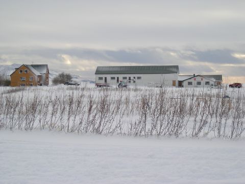 2001 Jeep Wrangler - A rural landscape covered in snow, farm buildings and several vehicles under a cloudy sky.