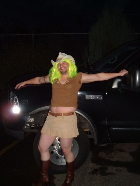 1989 Ford Bronco - A person dressed in a humorous costume poses next to a dark-colored truck at night.