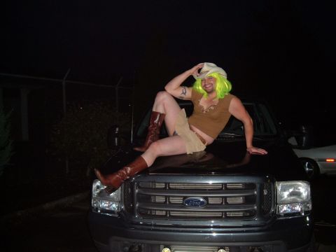 1989 Ford Bronco - A person dressed in a costume sits on the hood of a black Ford truck at night.