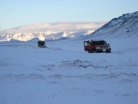 2001 Jeep Wrangler - Two SUVs are stopped in a wide, snow-covered area with mountains visible in the distance.