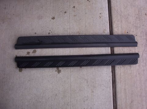1994 Ford Probe - Two black plastic door sill plates with a diagonal tread pattern are shown laid out on a concrete surface.