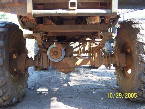 1987 Ford Bronco - Close-up of a truck's rear axle and suspension components, with a date stamp and website logo.