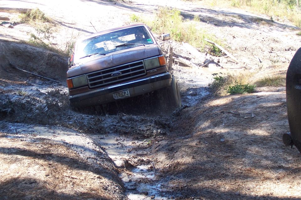 Ford Bronco driving through a muddy ditch