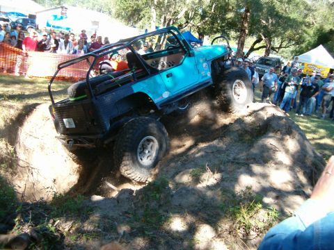 1991 Ford Bronco - A modified Jeep Wrangler navigates an obstacle course during an event.