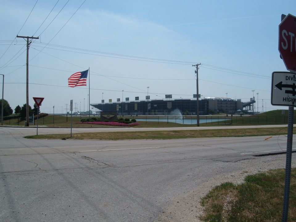 Roadside view of a stadium with an American flag and stop sign