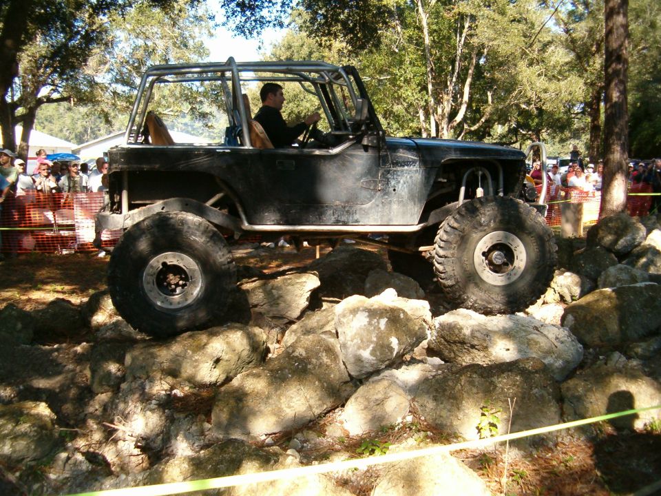 Side view of a dark blue and white 1980-1986 Ford Bronco with large tires