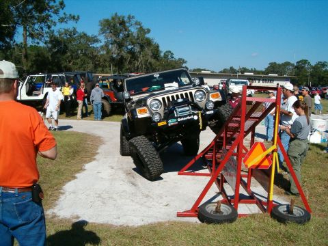 1991 Ford Bronco - A Jeep Wrangler navigates an obstacle course during an event.