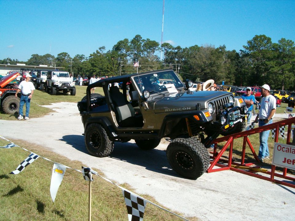 Gray Jeep Wrangler Rubicon with off-road tires on a ramp