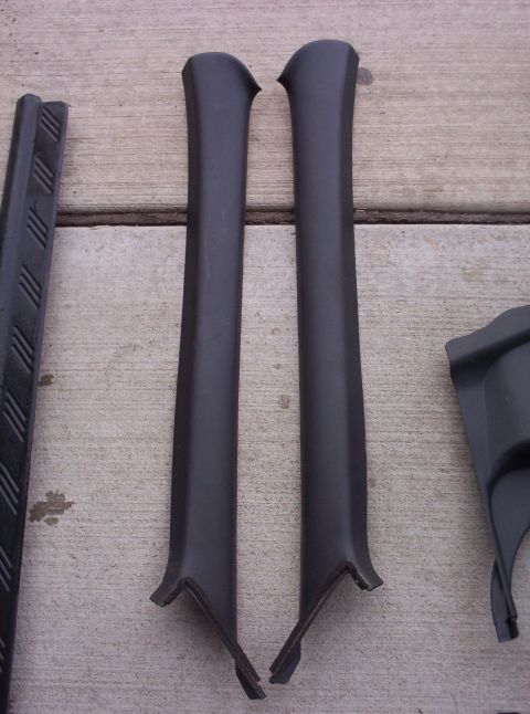 1994 Ford Probe - Interior trim pieces, possibly from a car, laid out on a concrete surface.