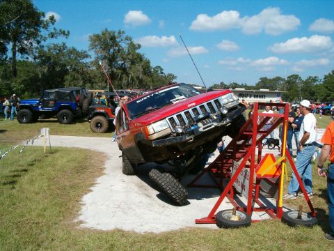 1991 Ford Bronco - Jeep Grand Cherokee on obstacle course at an off-road event.