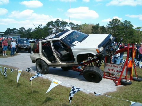 1991 Ford Bronco - A heavily modified Jeep Grand Cherokee is displayed with its doors removed and lifted on a custom frame.