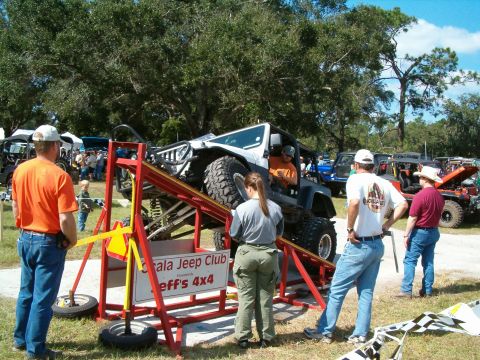 1991 Ford Bronco - A highly modified Jeep Wrangler is shown on an obstacle course at an outdoor event.