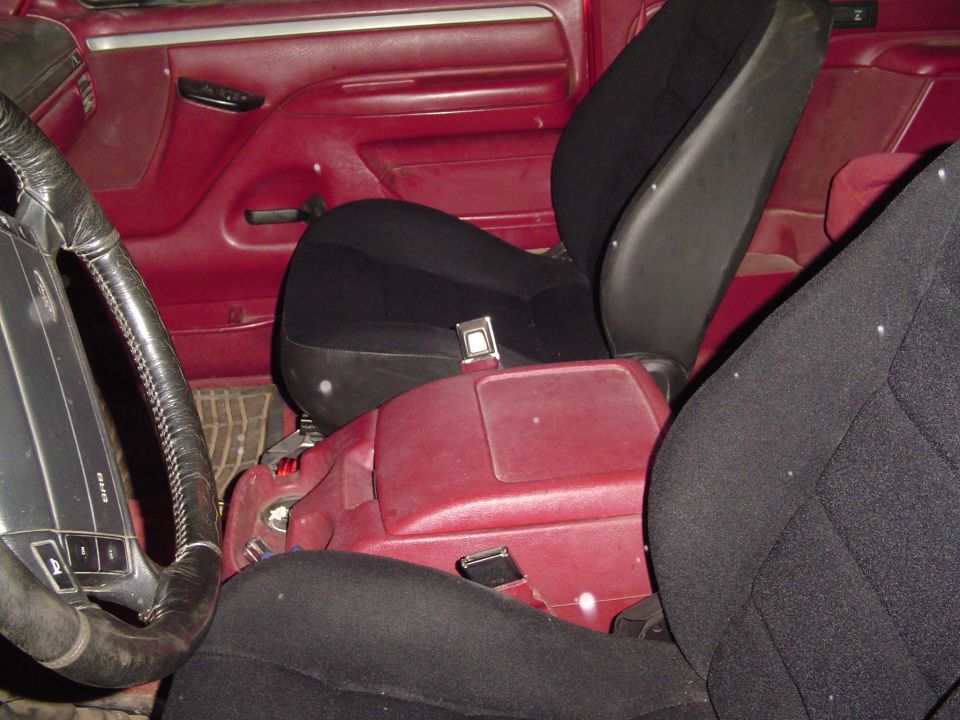 Red interior with black seats and a center console. Steering wheel visible