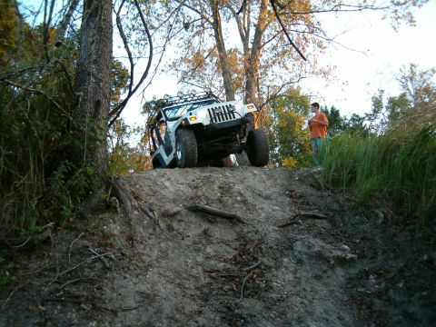 1991 Ford Bronco - A white Jeep Wrangler navigates an off-road trail, its capabilities.